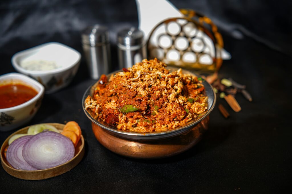 The Benefits Of Tumeric Delicious Indian biryani served in a traditional dish with fresh vegetables and spices on a dark background.