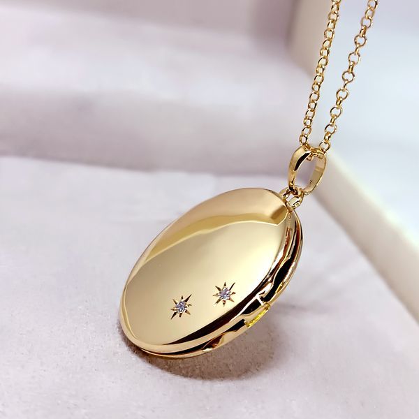 relicário em ouro 18k oval liso personalizado com dois diamantes