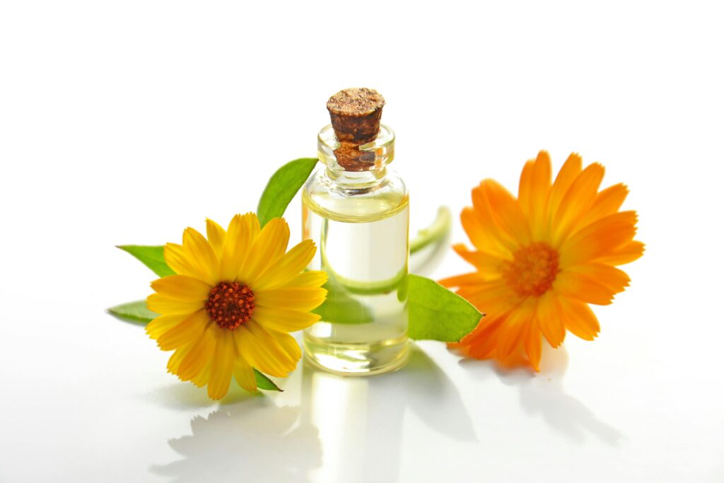 MEDICINAL BENEFITS OF A CHAMOMILE FLOWER A glass bottle of aromatic oil with chamomile flowers on a white background.